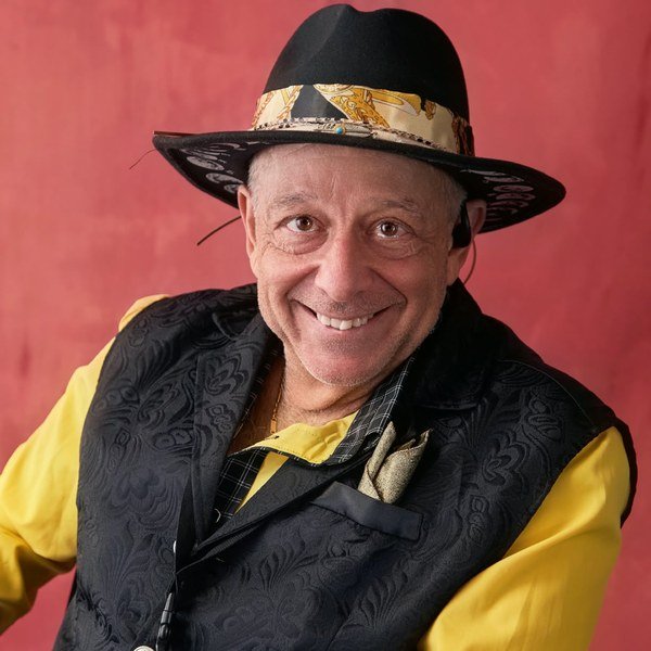 Tony Lawand in a yellow shirt and black hat