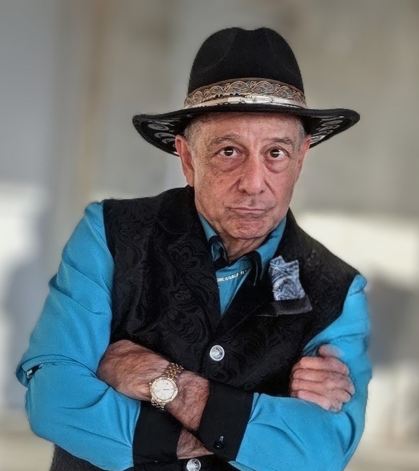 Tony Lawand in a black hat, black vest and turquoise shirt