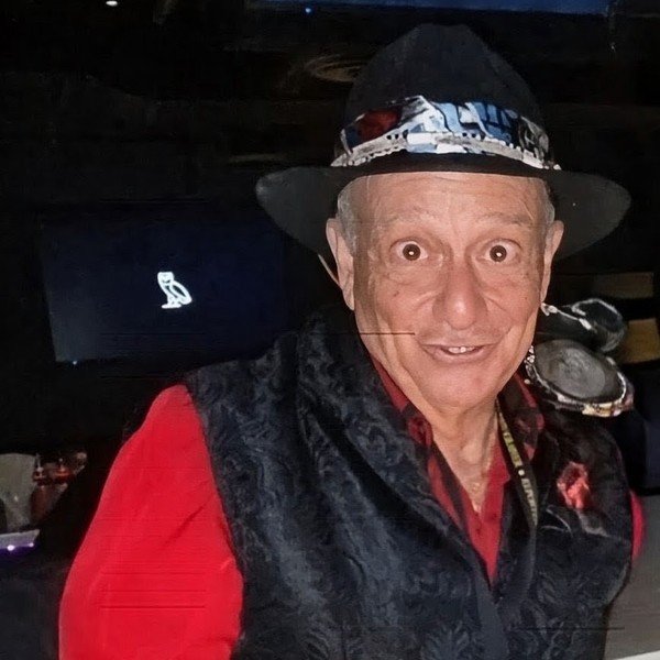 Tony Lawand pointing, in a red shirt and black hat
