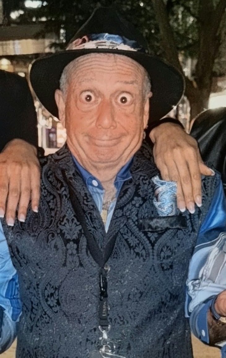 Tony Lawand wide-eyed with hands on his shoulders